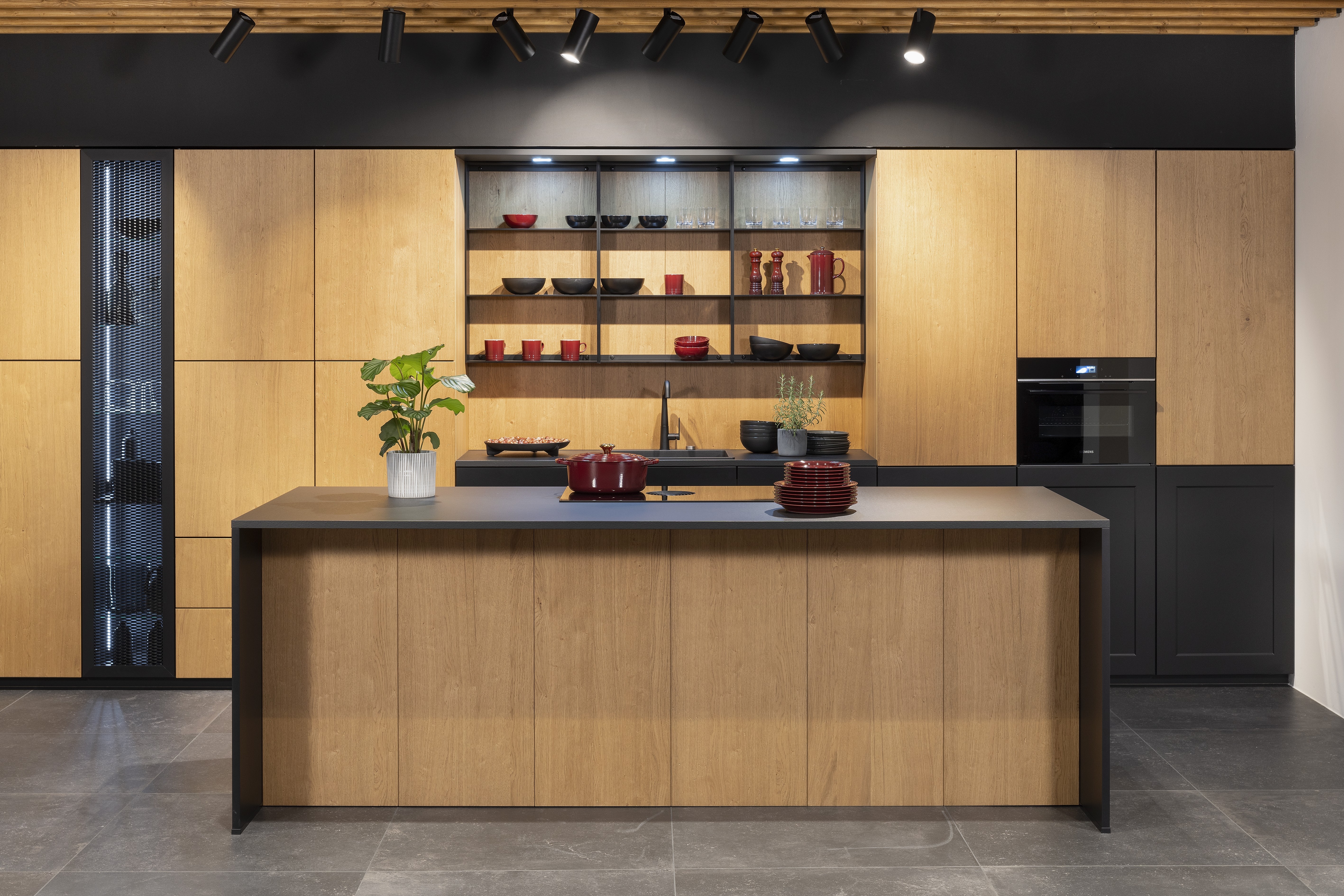 APL: Schwarz Pro Front: Frame Lack Schwarz Front: neoNature Eiche Cottage Korpus: Graphit Griff: PTO Geräte: Siemens und Muldenlüfter Bora Armatur: Gesi Spüle: Franke   Features: Echtholzfront mit Oberflächenbearbeitung (Cottage/Vintage-Look), Kombination von glatter Front und Kassette, Kochfeld mit Muldenlüfter, Vitrinen beleuchtet mit Metallgitter, Nischenrückwand in Frontmaterial Eiche Cottage, Downlights, Insellösung mit Thekencharakter, Kompaktbackofen Siemens.  