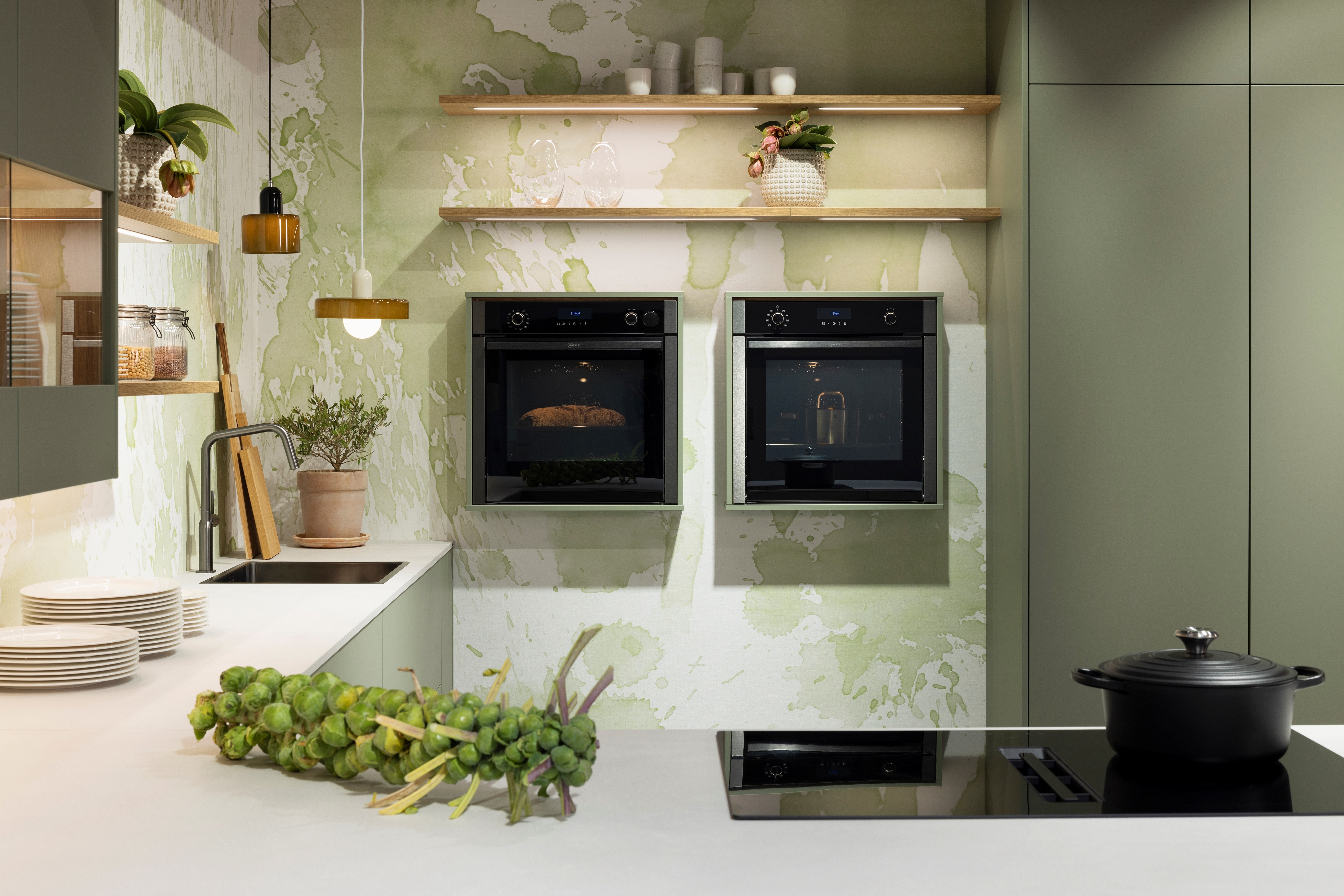 APL: 794 Beton Seidengrau NB (Xtra Ceramic) Korpus: 198 Eiche Sierra Front: Senso 495 Lack, Olive Premium matt Geräte: Neff Slide&Hide Armatur: Gessi  Spüle: Teka  Features: Trendfarbe Olive, Push to open, Tapete, neuer Schubkasten, Wandeinbau Backofen, beleuchtete Regale, beleuchtete Vitrinen, Weinflaschenregal, Schubkästen und Korpus in Eiche Sierra, Premium matte Oberfläche mit Antifingerprint, Nischenrückwand in Rillenoptik.