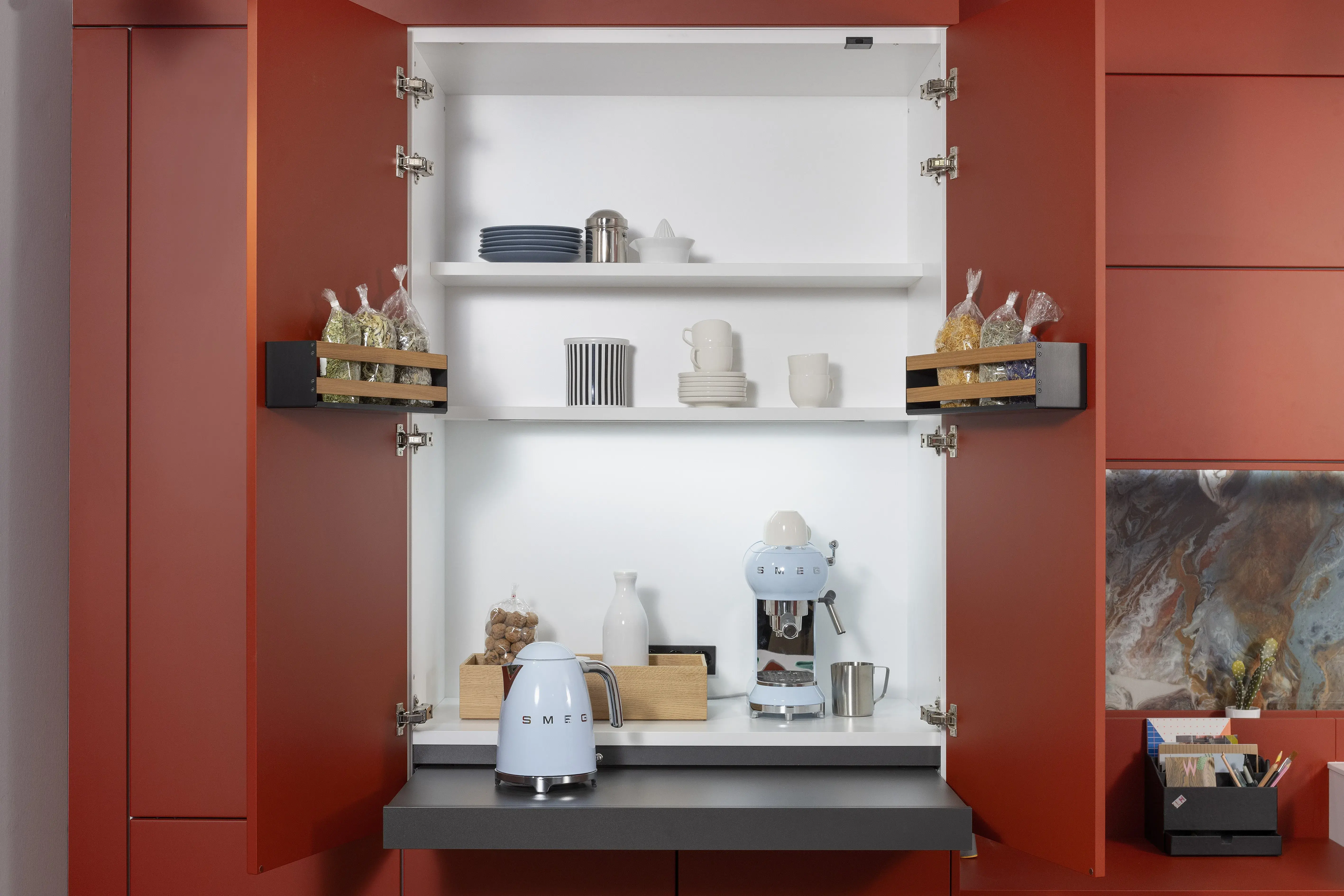 APL: Systeme Blanco Zeus matt Front: Herbstrot samtmatt AFP Front: Tiefblau samtmatt AFP Korpus: Kristallweiß/Naturweiß Griff: Metall Weiß lackiert Geräte: Siemens, Abzugshaube Airforce Armatur: Franke Spüle: Franke   Features: Farbe in der Küche, quadratische Kücheninsel mit Kochfeld und Dunstabzug, Kontrastelemente in Weiß (Griffe, APL, Spüle, Wasserhahn und Backofen), weißer BACKOFEN, kleine Designküche, junge Küche, Nischenrückwand als Motivfliese (Schüller), Arbeitsplatz, „versteckte“ Kaffeeküche 